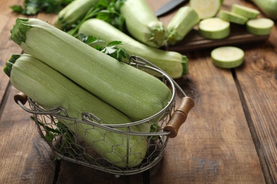 Zucchinis with parsley in basket on wooden table