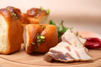 Delicious pampushky (buns with garlic) and salo on wooden board, closeup