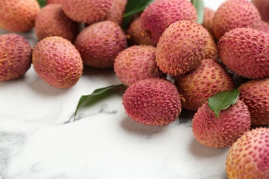 Photo of Fresh ripe lychee fruits on white marble table