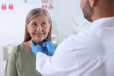 Photo of Endocrinologist examining thyroid gland of patient at hospital, closeup