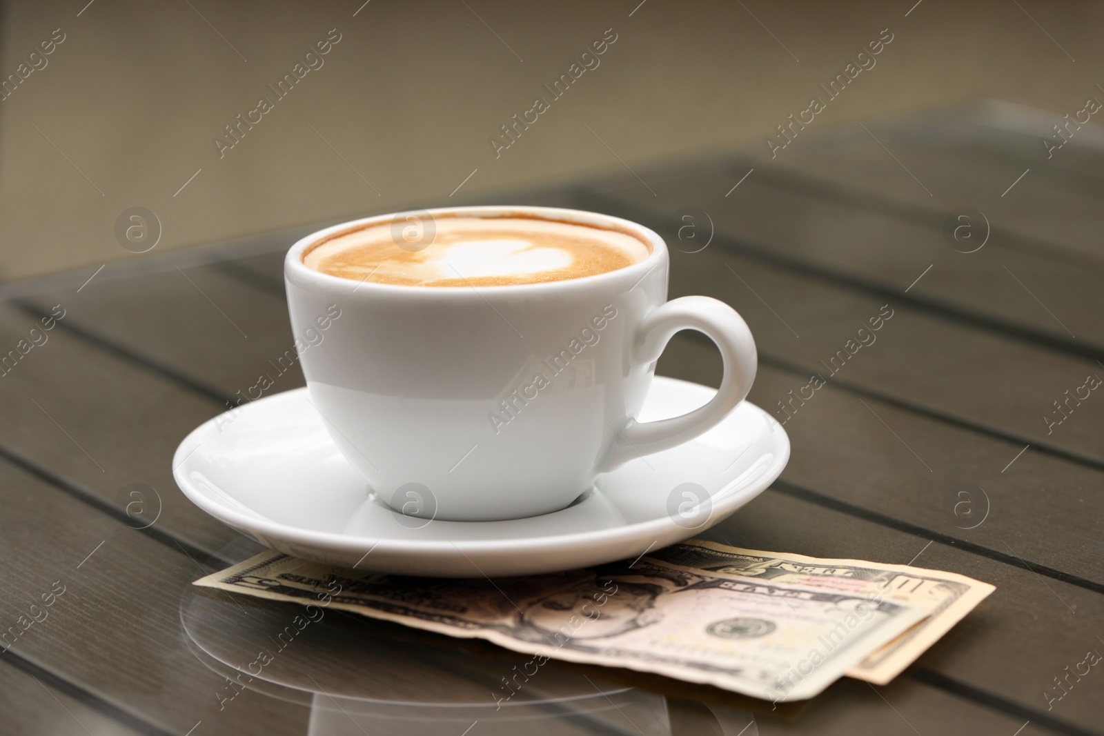 Photo of Tips and coffee on table in outdoor cafe