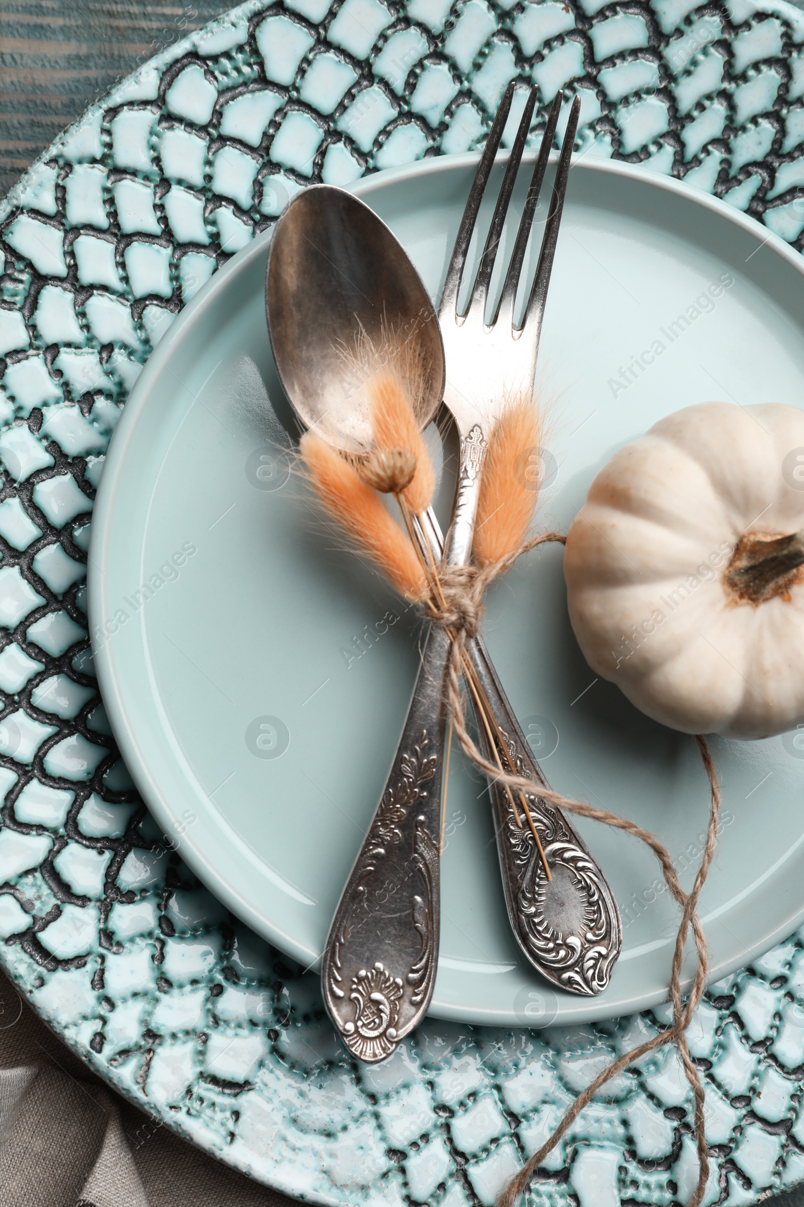 Photo of Autumn table setting with pumpkin on blue wooden background, closeup