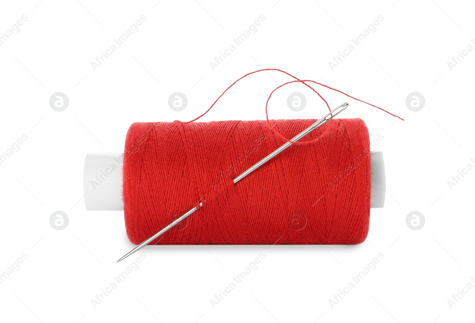 Photo of Spool of red sewing thread with needle isolated on white