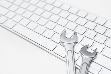 Photo of Wrenches and computer keyboard on light background. Concept of technical support