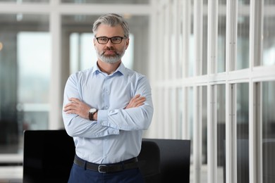 Photo of Handsome man with crossed arms in office, space for text. Lawyer, businessman, accountant or manager