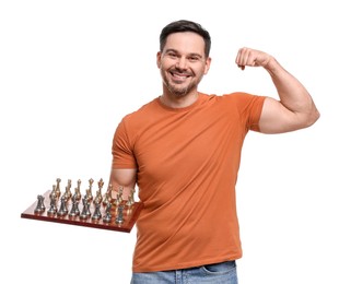 Smiling man holding chessboard with game pieces and showing bicep on white background