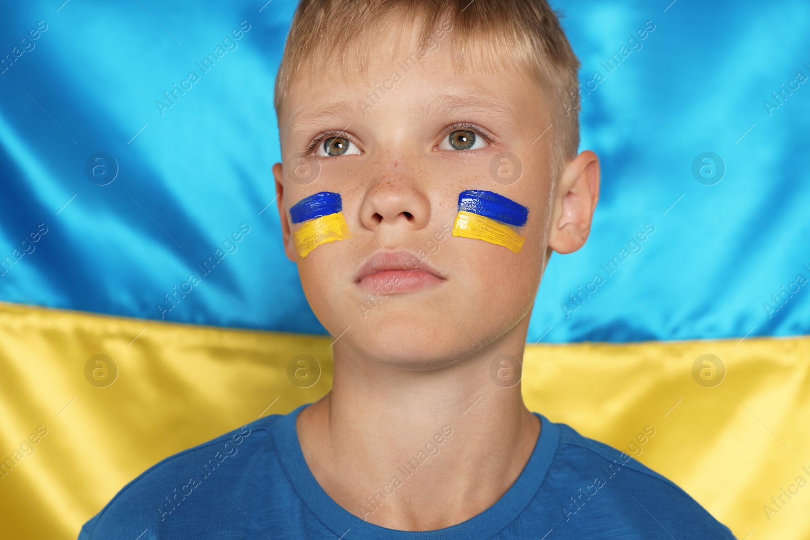 Photo of Little boy near Ukrainian flag. No war concept