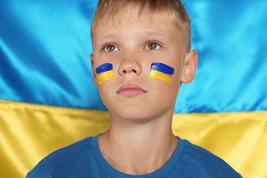 Little boy near Ukrainian flag. No war concept