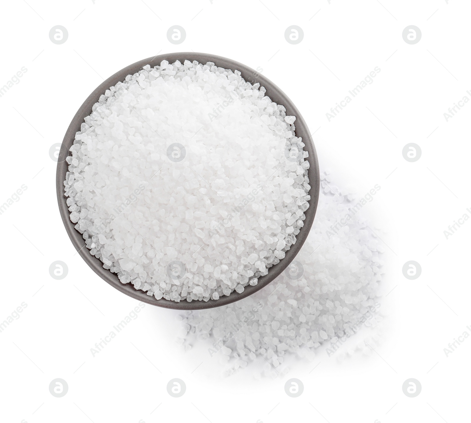 Photo of Ceramic bowl and heap of natural sea salt isolated on white, top view