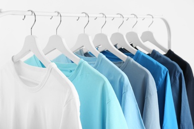 Photo of Men's clothes hanging on wardrobe rack against white background