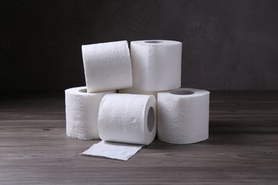 Photo of Soft toilet paper rolls on wooden table