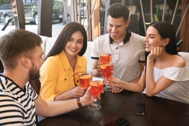 Friends with Aperol spritz cocktails resting together at restaurant