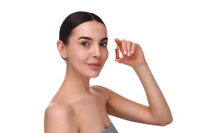 Beautiful young woman holding skincare ampoule on white background