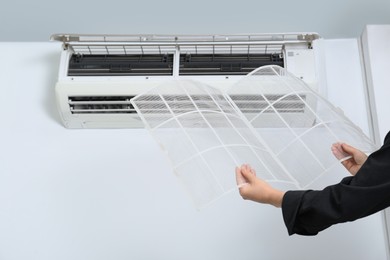 Woman holding air conditioner filters indoors, closeup