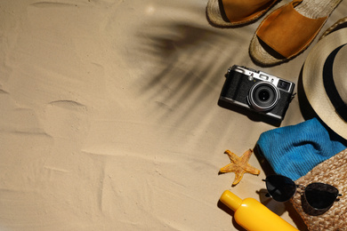 Beach accessories on sand, flat lay. Space for text