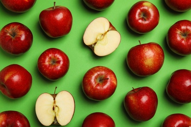 Flat lay composition with ripe juicy red apples on green background