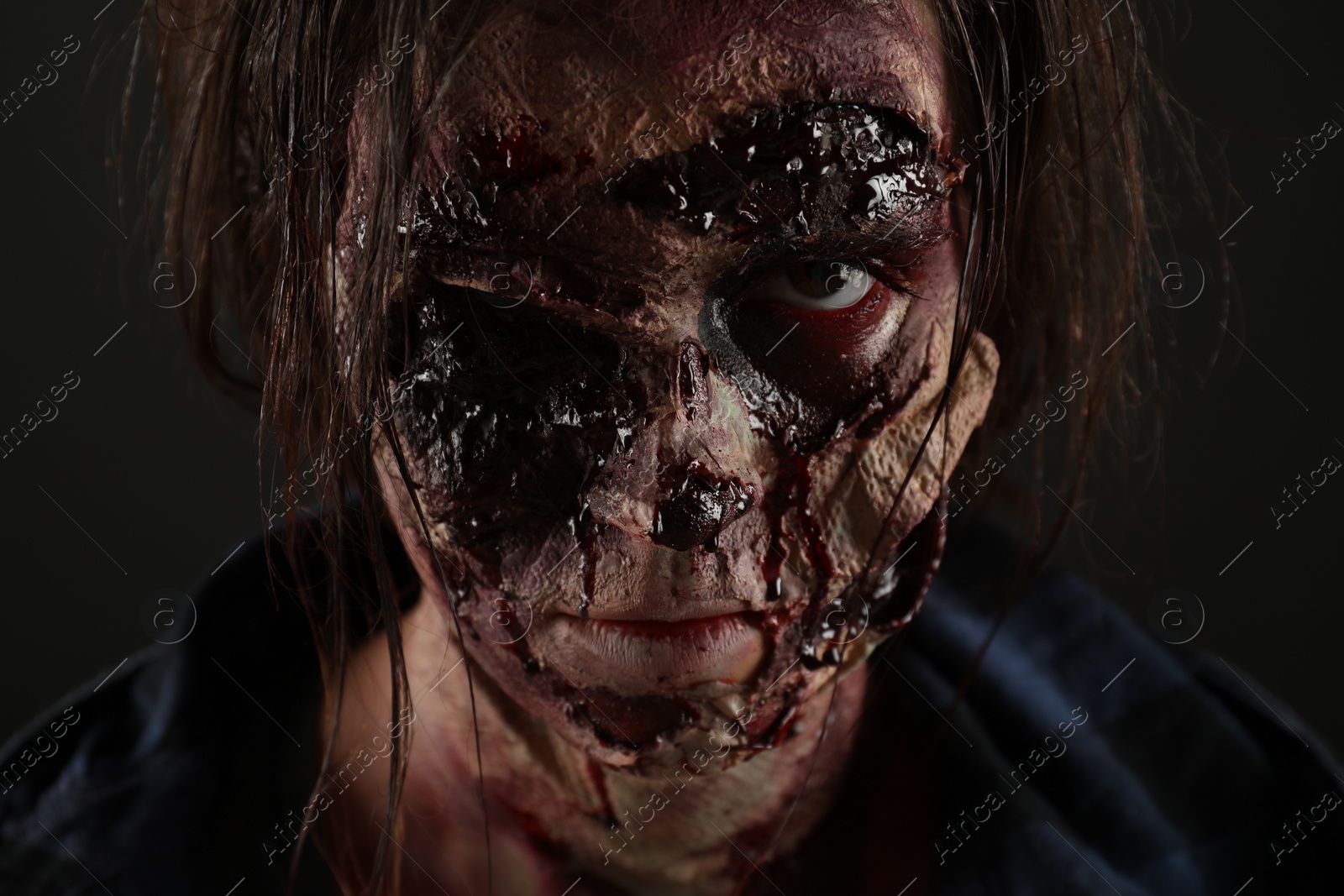 Photo of Scary zombie on dark background, closeup. Halloween monster