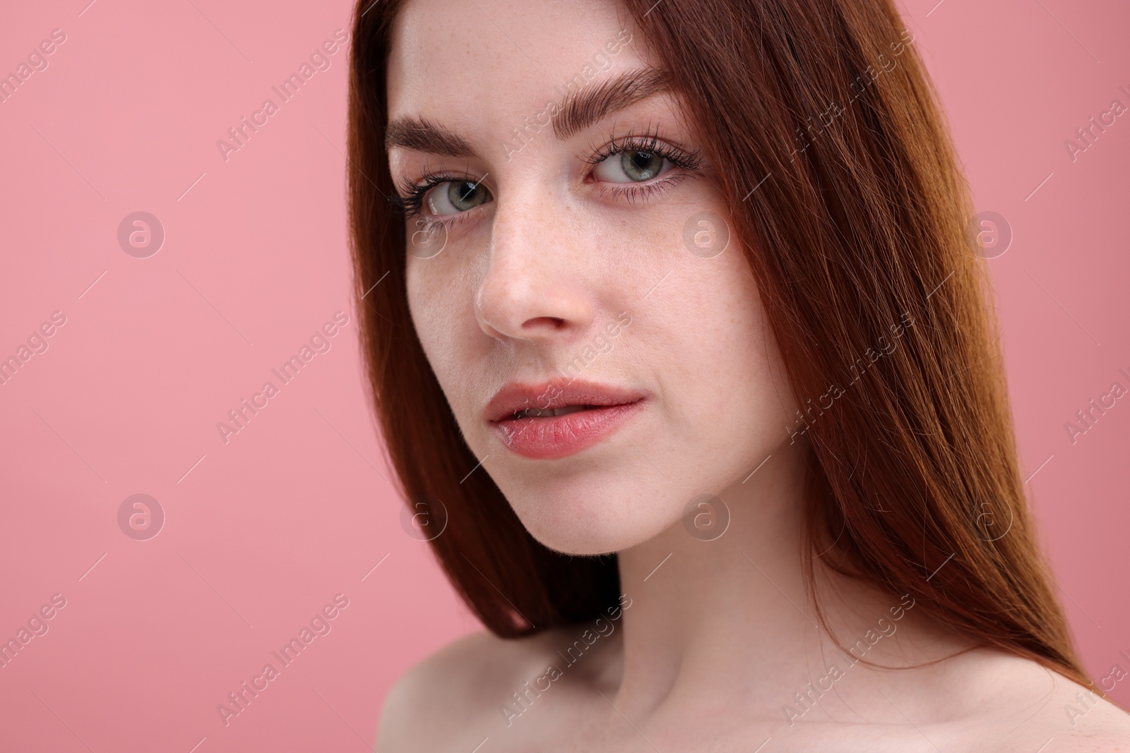 Photo of Portrait of beautiful woman with freckles on pink background, closeup