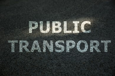 Image of Text PUBLIC TRANSPORT written on asphalt road 