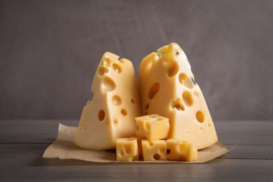 Photo of Pieces of delicious cheese on wooden table