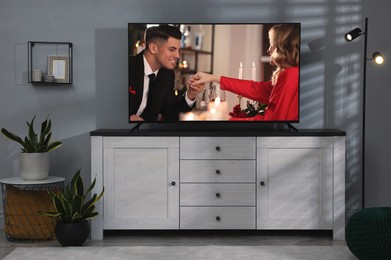 Image of Scene of romantic movie on TV in room