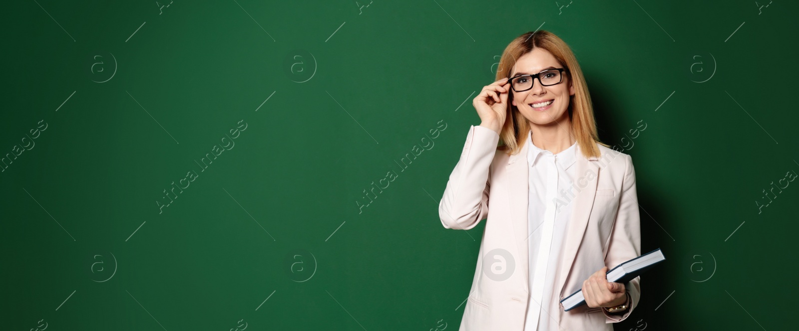 Image of Portrait of beautiful teacher with book near chalkboard, space for text. Banner design