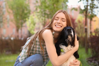 Young woman hugging her English Springer Spaniel dog outdoors