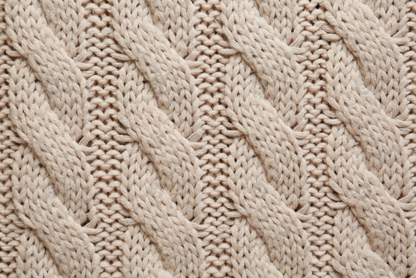 Photo of Beige knitted fabric with beautiful pattern as background, top view