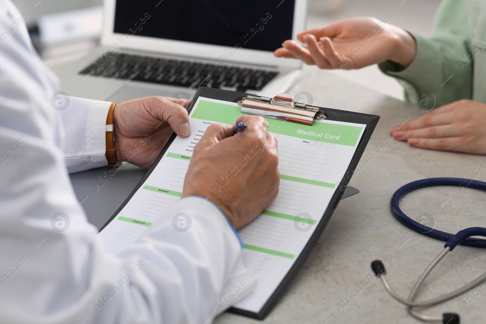 Photo of Doctor filling patient's medical card in clinic, closeup