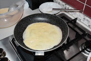 Photo of Frying delicious crepe on pan in kitchen