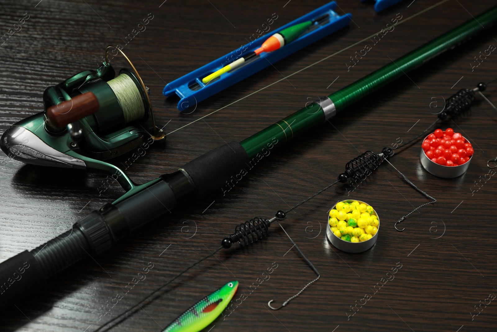 Photo of Modern fishing tackle on dark wooden background