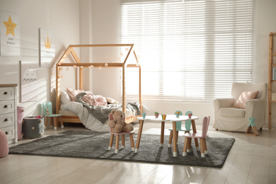 Small table and chairs with bunny ears in children's bedroom interior