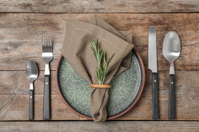 Photo of Beautiful table setting with cutlery, napkin and plate on wooden background, top view