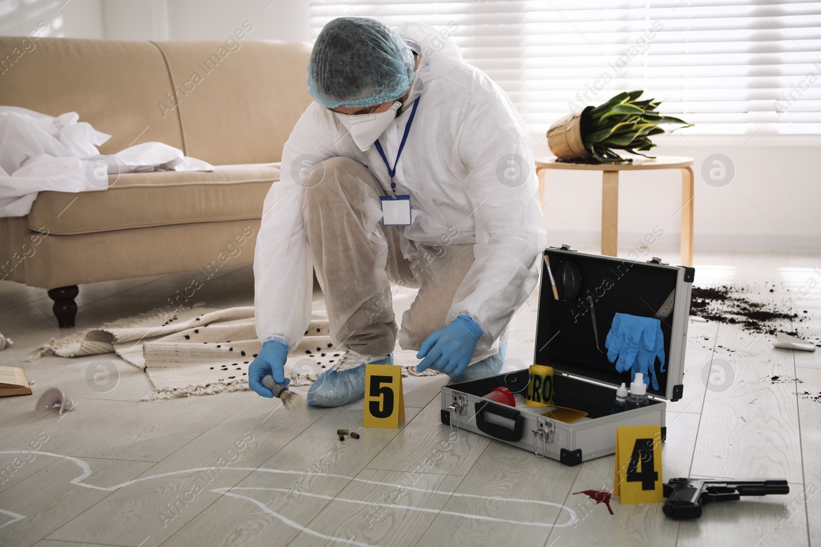 Photo of Investigator in protective suit working at crime scene