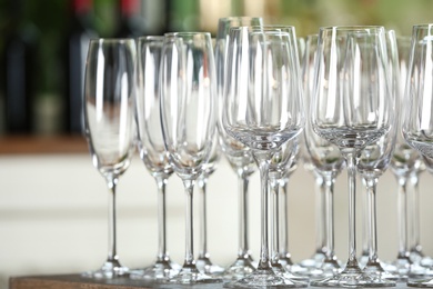 Photo of Empty glasses on wooden table against blurred background