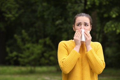Photo of Woman suffering from seasonal spring allergy outdoors, space for text