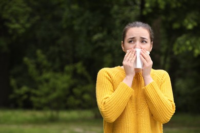 Woman suffering from seasonal spring allergy outdoors, space for text