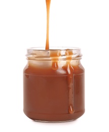 Photo of Tasty caramel sauce pouring into jar isolated on white