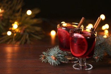 Photo of Mulled wine with cinnamon, anise and orange on table. Space for text