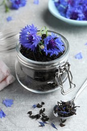 Dry tea leaves and cornflowers on light table