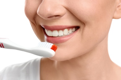 Photo of Young woman brushing her teeth on white background, closeup