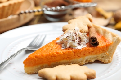 Photo of Slice of delicious homemade pumpkin pie on plate, closeup
