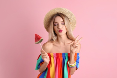 Pretty young woman with juicy watermelon on color background