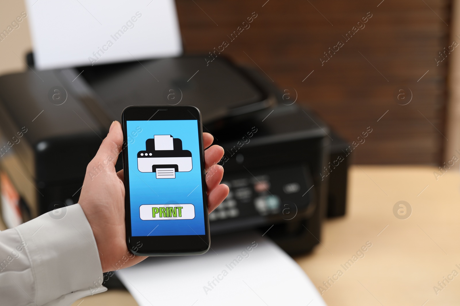 Photo of Man using printer management application on mobile phone indoors, closeup and space for text