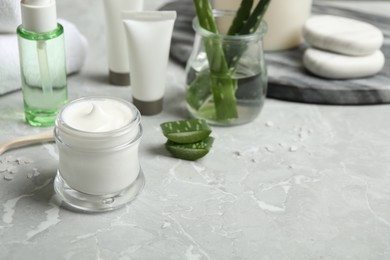 Photo of Different cosmetic products and aloe on grey marble table