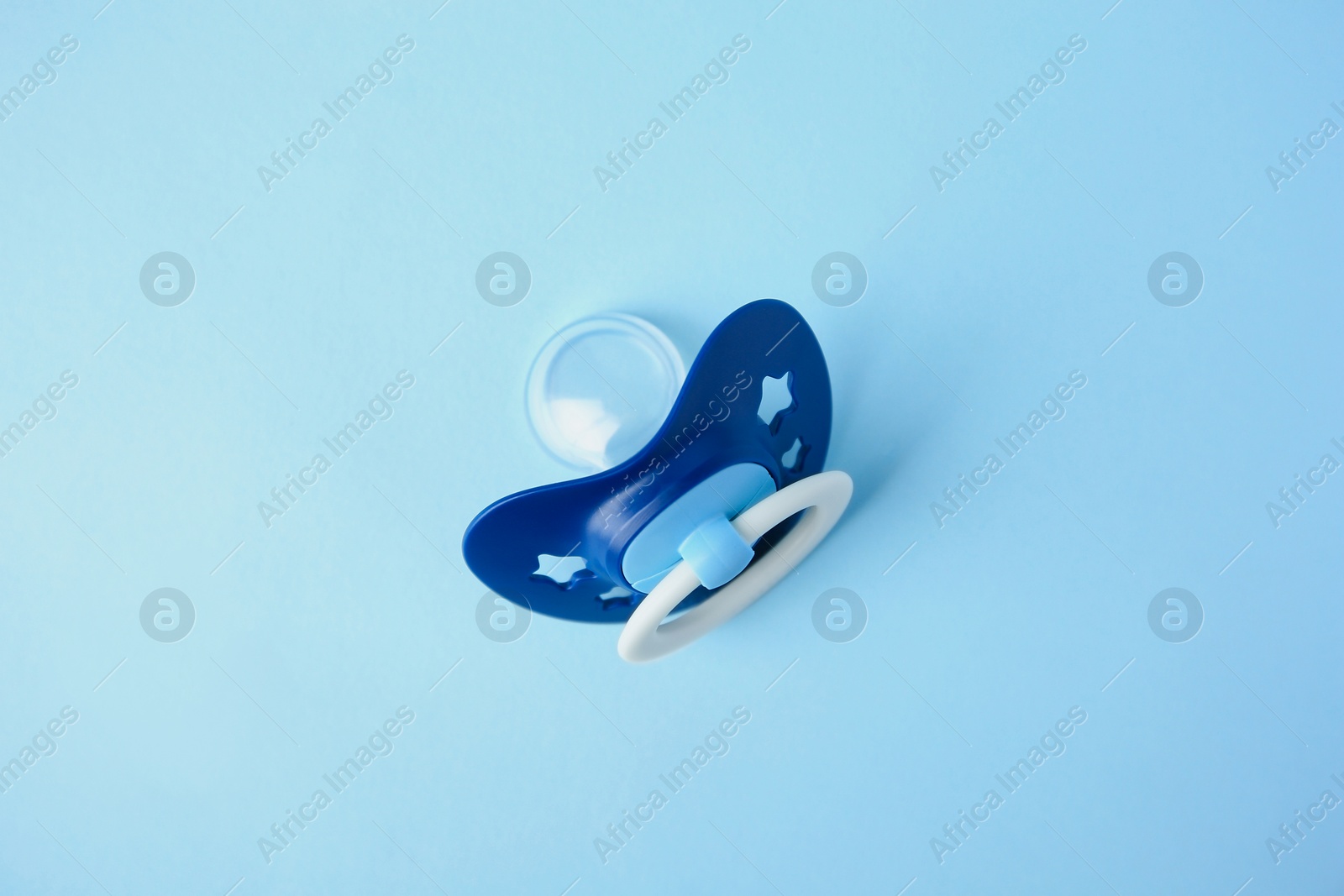 Photo of One baby pacifier on light blue background, top view