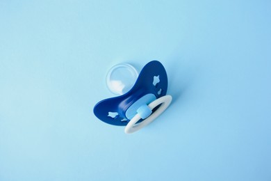 Photo of One baby pacifier on light blue background, top view