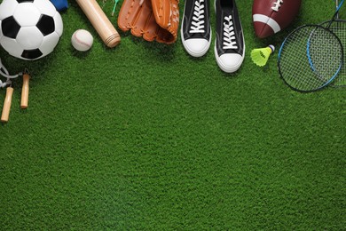 Photo of Different sport tools on green grass, flat lay. Space for text