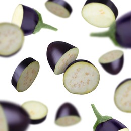 Slices of eggplants falling on white background