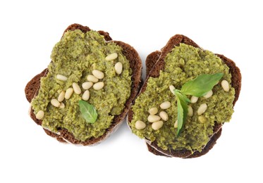 Photo of Tasty bruschettas with pesto sauce, nuts and fresh basil isolated on white, top view